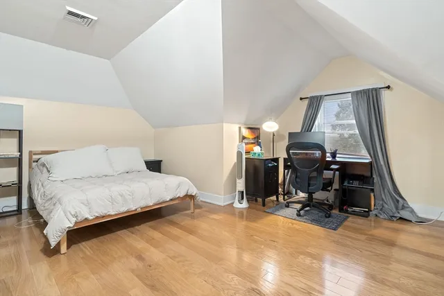 a bedroom with a bed and wooden floor