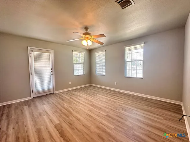 wooden floor in an empty room with a window
