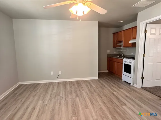 a view of a kitchen with wooden floor and stainless steel appliances