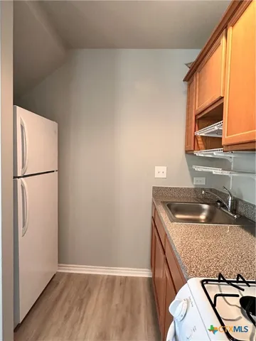 a kitchen with a sink a refrigerator and a stove