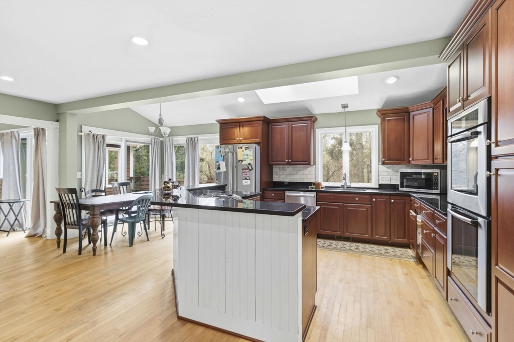 17 Wellesley Street Weston, MA 02493 - Photo 5 of 30 a kitchen with stainless steel appliances granite countertop a stove top oven a sink a dining table and chairs