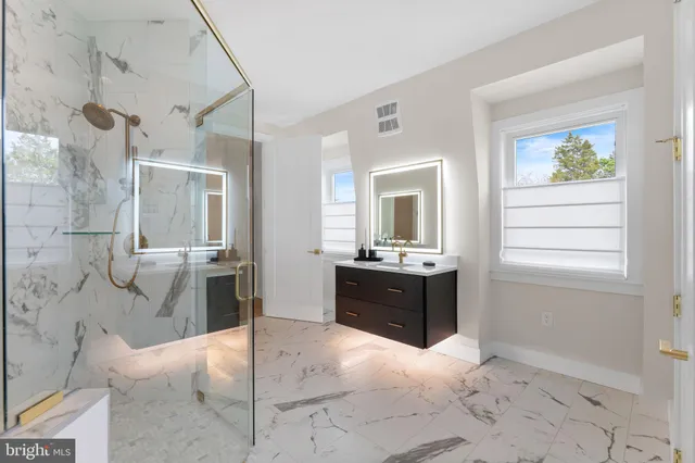 a bathroom with a granite countertop sink a toilet and shower