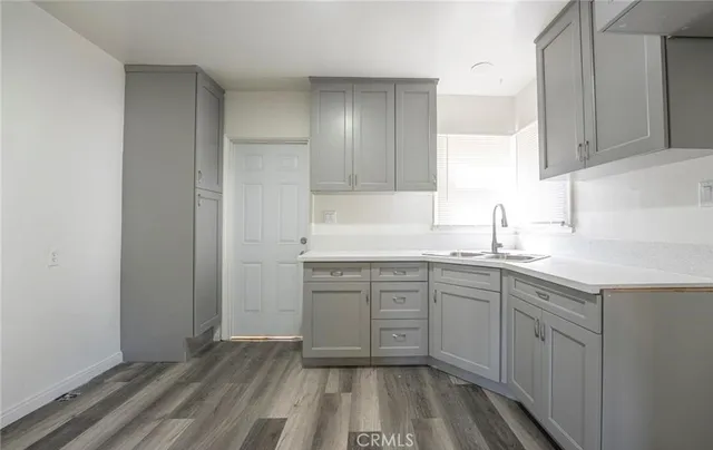a kitchen with sink cabinets and wooden floor