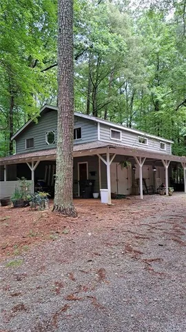 a front view of a house with yard and trees in the background