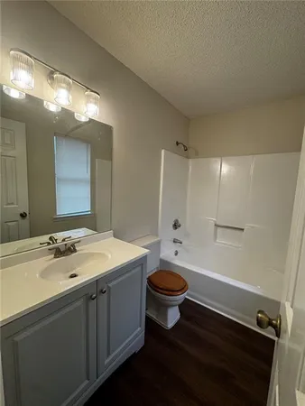 a bathroom with a sink a toilet a mirror a vanity and bathtub