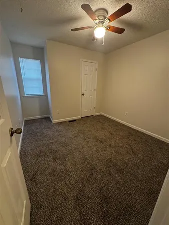 en empty room with windows and fan