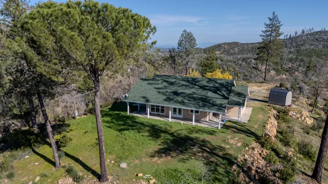 aerial view of a house with a yard and large trees