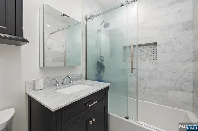 a bathroom with a sink shower and a mirror