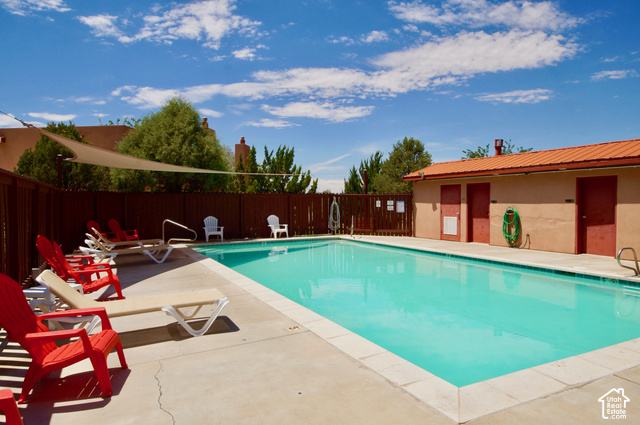 3299 Fairway Loop Moab, UT 84532 - Photo 21 of 23 Outdoor swimming pool with concrete decking, a privacy fence, and a shade sail