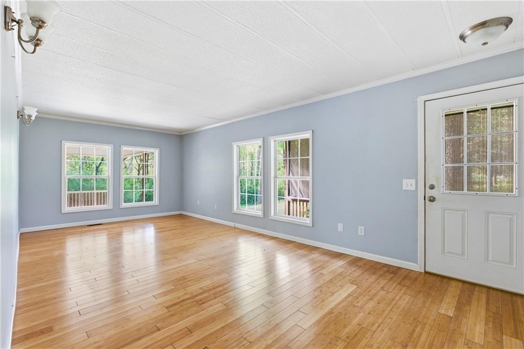 6668 Belton Bridge Road Lula, GA 30554 - Photo 21 of 29 a view of empty room with wooden floor and fan