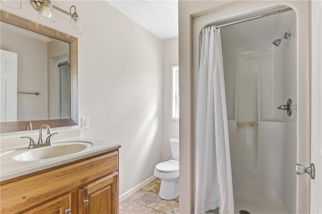 6668 Belton Bridge Road Lula, GA 30554 - Photo 26 of 29 a bathroom with a granite countertop sink toilet and shower