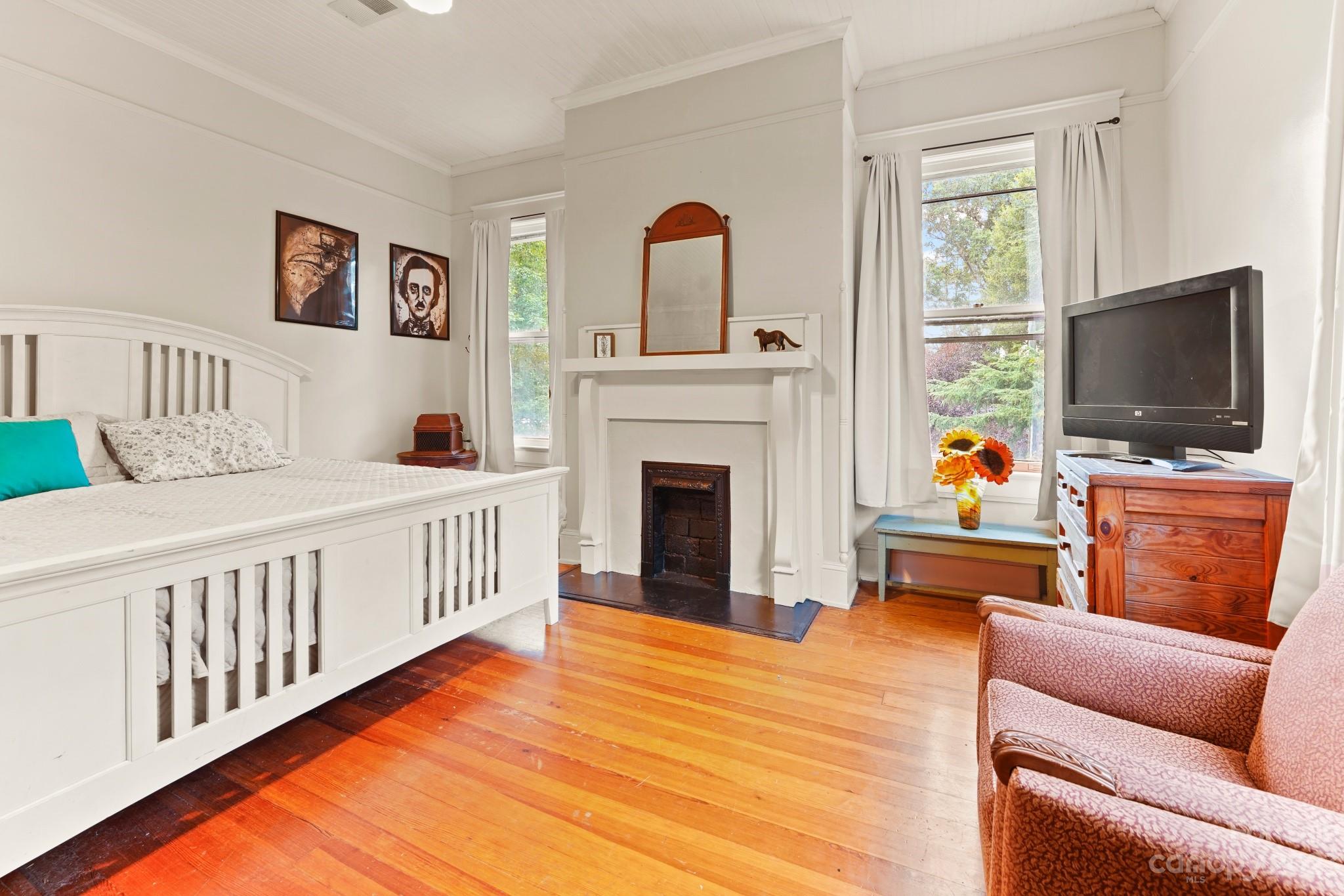 810 East Franklin Street Monroe, NC 28112 - Photo 24 of 47 a bedroom with furniture fireplace and flat screen tv