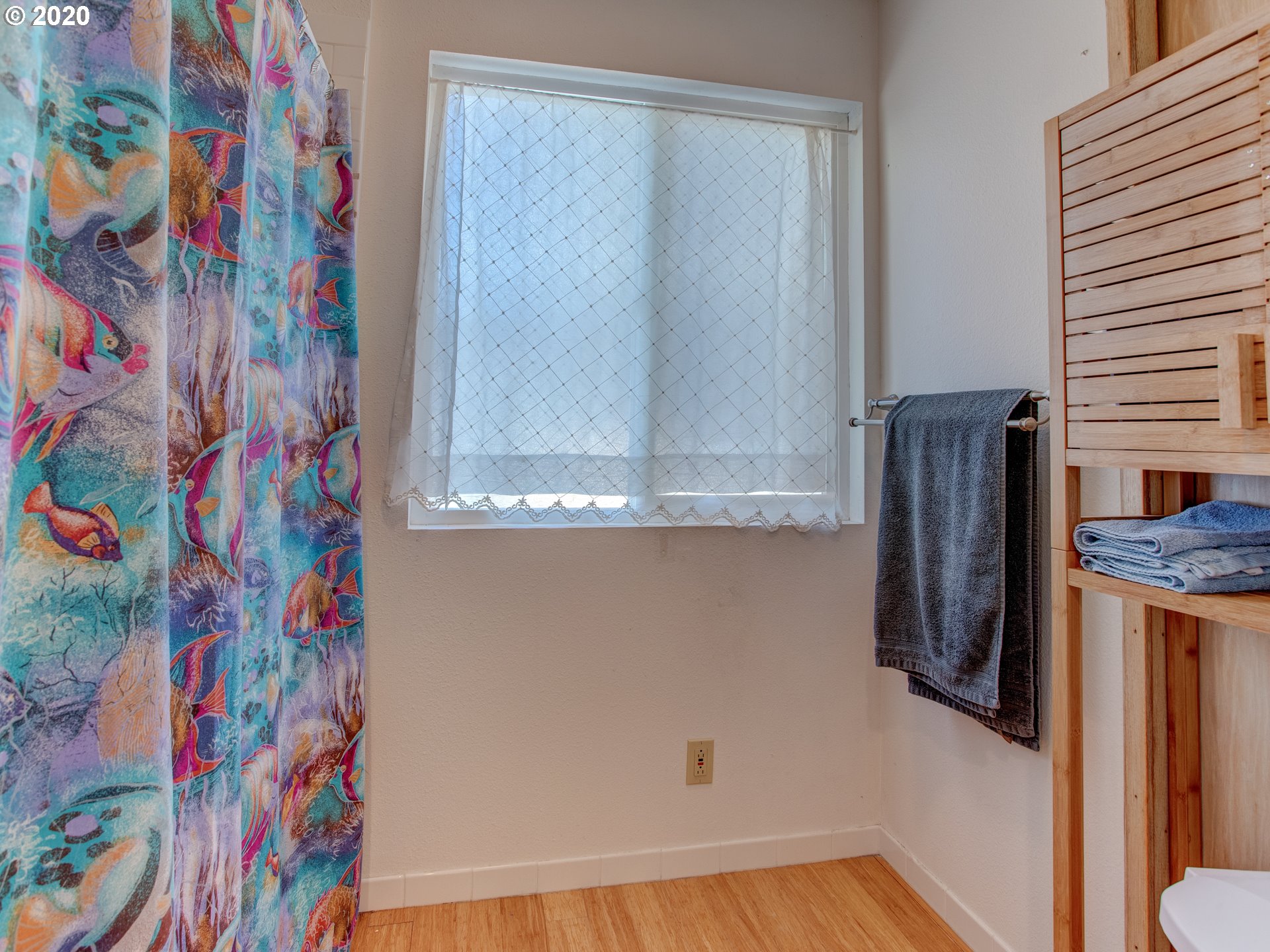 14998 Northwest Mill Road, Unit D Portland, OR 97231 - Photo 12 of 32 a bathroom with a granite countertop sink and a shower curtain