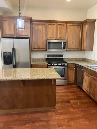 a kitchen with stainless steel appliances wooden cabinets a stove top oven a sink and dishwasher