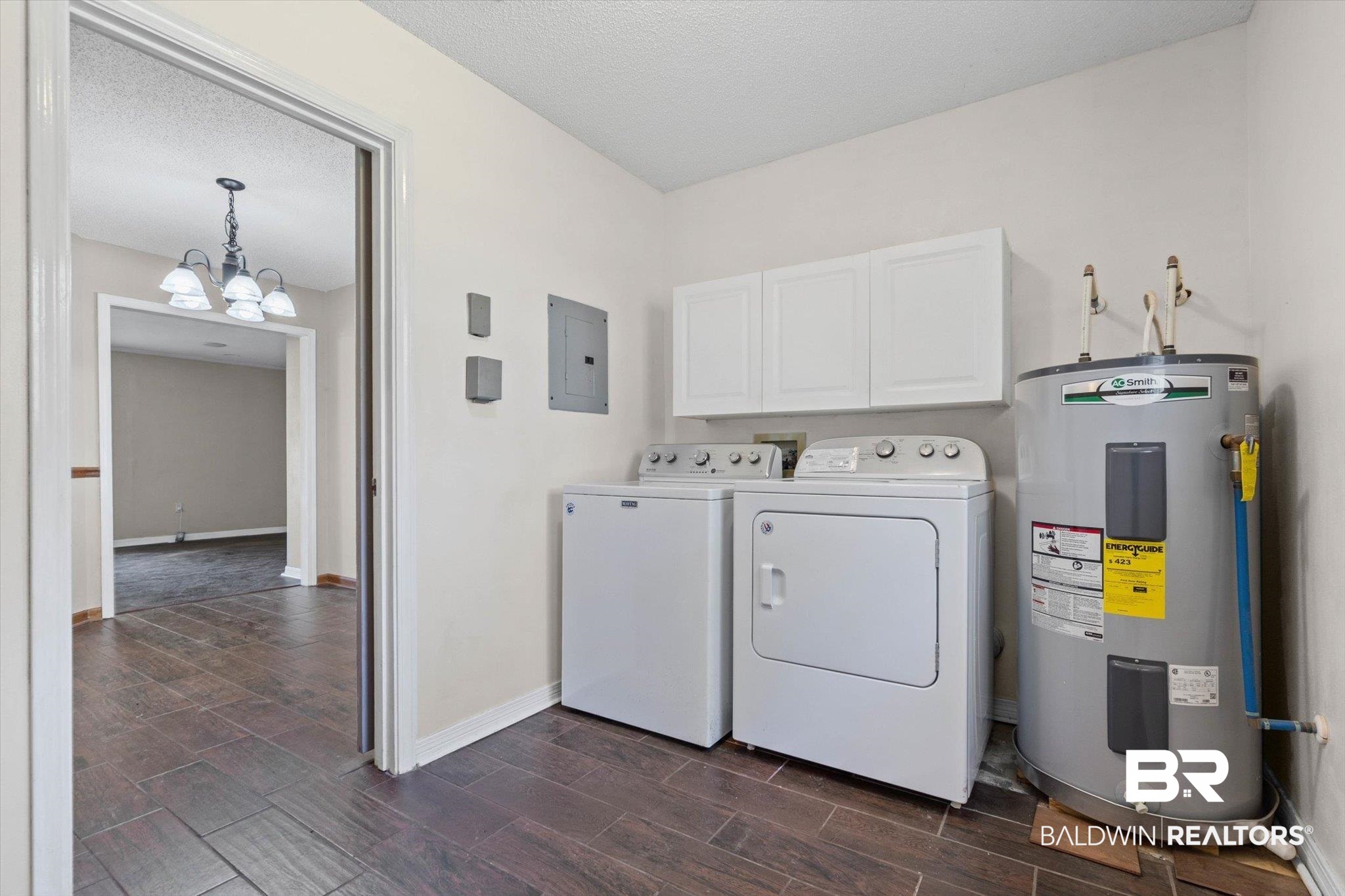 180 Creax Road Axis, AL 36505 - Photo 23 of 35 Laundry room featuring wood tiled floors, water heater, cabinet space, a textured ceiling, and a chandelier