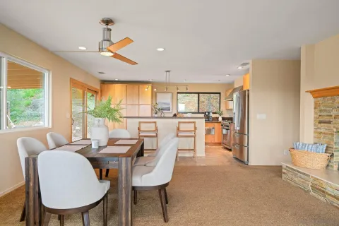 a dining room with furniture and a floor to ceiling window