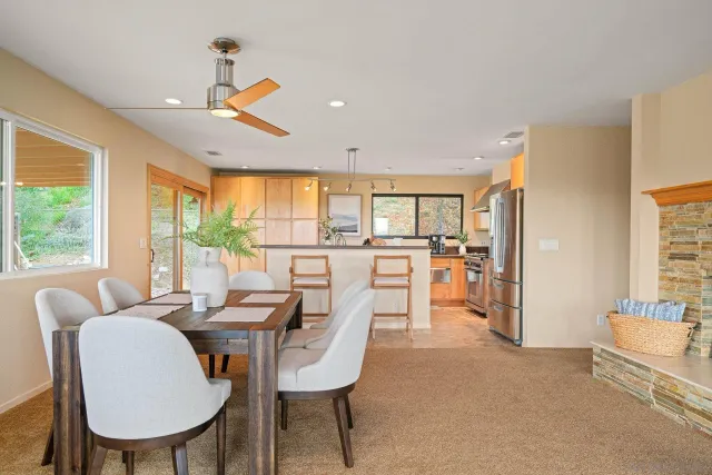 a dining room with furniture and a floor to ceiling window