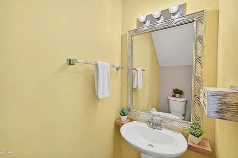 a bathroom with a sink mirror and a toilet