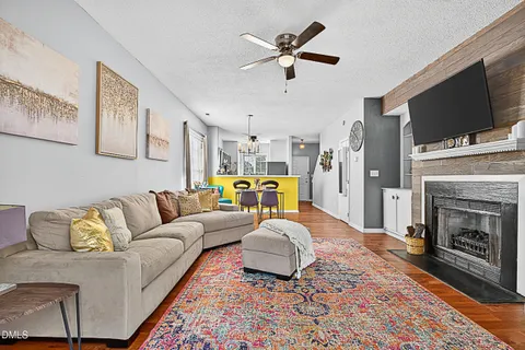a living room with furniture a flat screen tv and a fireplace