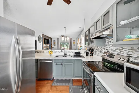 a kitchen with stainless steel appliances a sink stove and refrigerator