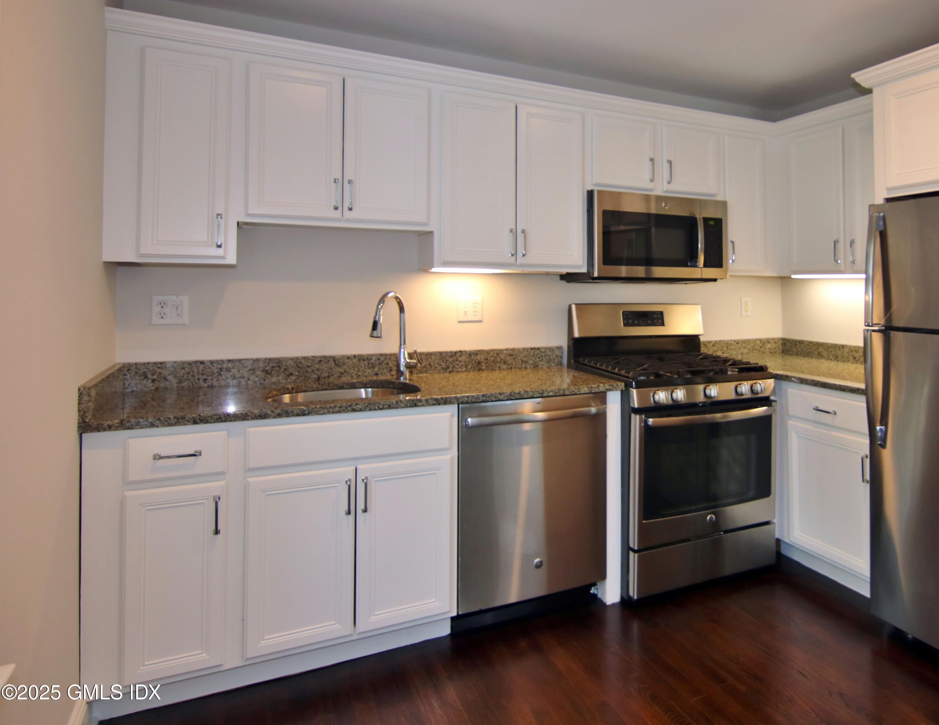 2 East Elm Street, Unit 31 Greenwich, CT 06830 - Photo 7 of 21 a kitchen with granite countertop white cabinets and stainless steel appliances