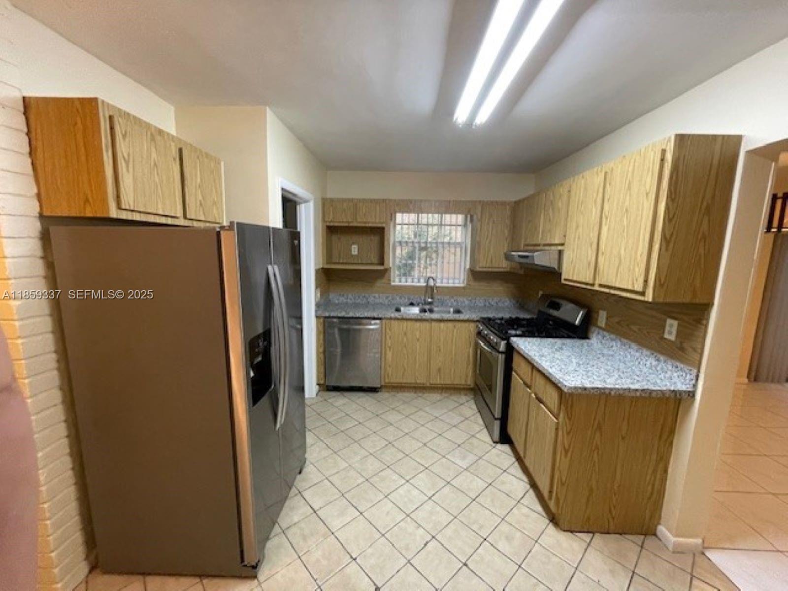 4831 Northwest 12th Street Lauderhill, FL 33313 - Photo 6 of 19 a kitchen with a refrigerator a sink and a stove