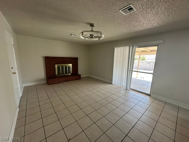 Tiled flooring and a classic brick fireplace anchor this welcoming living area.