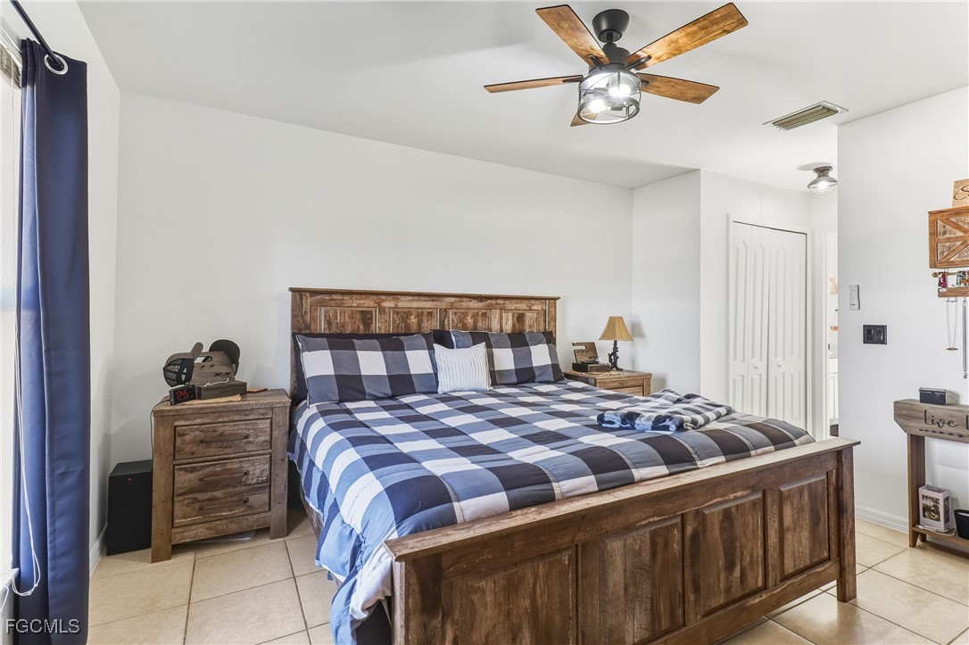 3910 23rd Street Southwest Lehigh Acres, FL 33976 - Photo 17 of 29 a bedroom with a bed and a chandelier