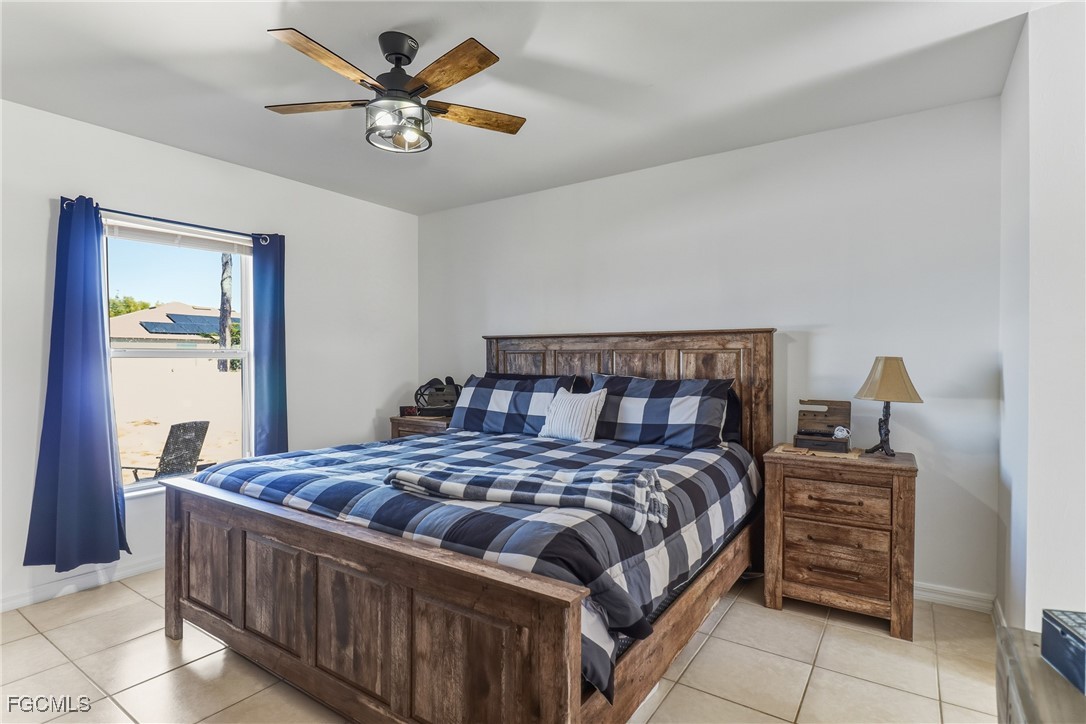 3910 23rd Street Southwest Lehigh Acres, FL 33976 - Photo 18 of 29 a bedroom with a bed and a chandelier