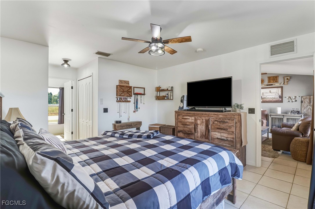 3910 23rd Street Southwest Lehigh Acres, FL 33976 - Photo 19 of 29 a bedroom with a bed and a flat screen tv