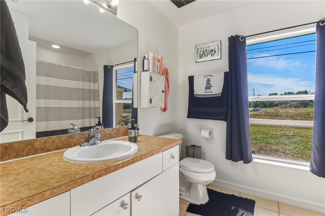 3910 23rd Street Southwest Lehigh Acres, FL 33976 - Photo 20 of 29 a bathroom with a granite countertop sink toilet and a mirror