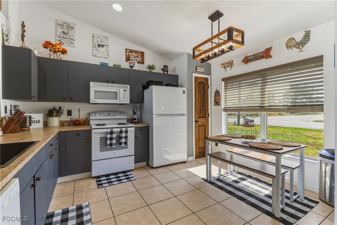 3910 23rd Street Southwest Lehigh Acres, FL 33976 - Photo 3 of 29 a kitchen with stainless steel appliances a refrigerator sink and stove