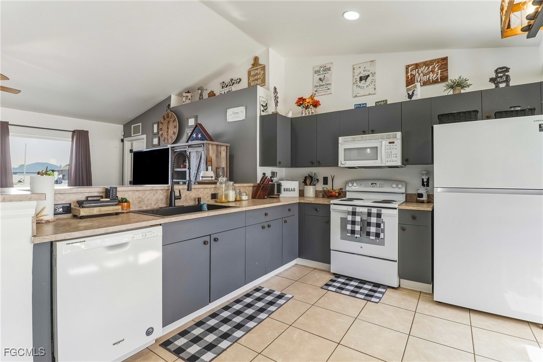 3910 23rd Street Southwest Lehigh Acres, FL 33976 - Photo 5 of 29 a kitchen with stainless steel appliances granite countertop a refrigerator sink and cabinets