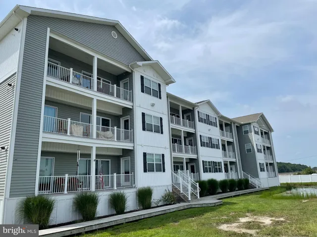 a front view of a residential apartment building with a yard
