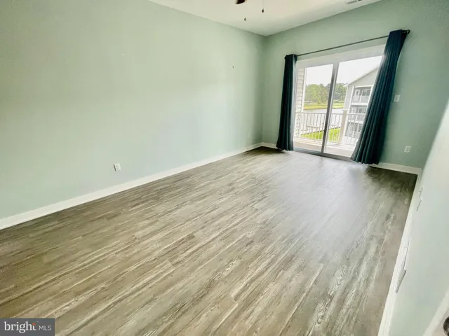 an empty room with wooden floor and sliding door