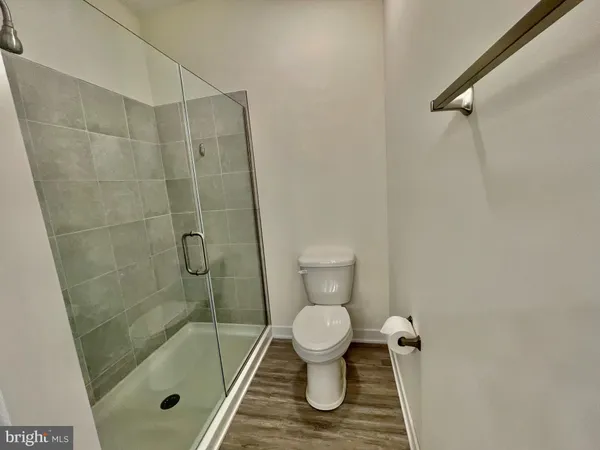a bathroom with a granite countertop toilet a sink and shower