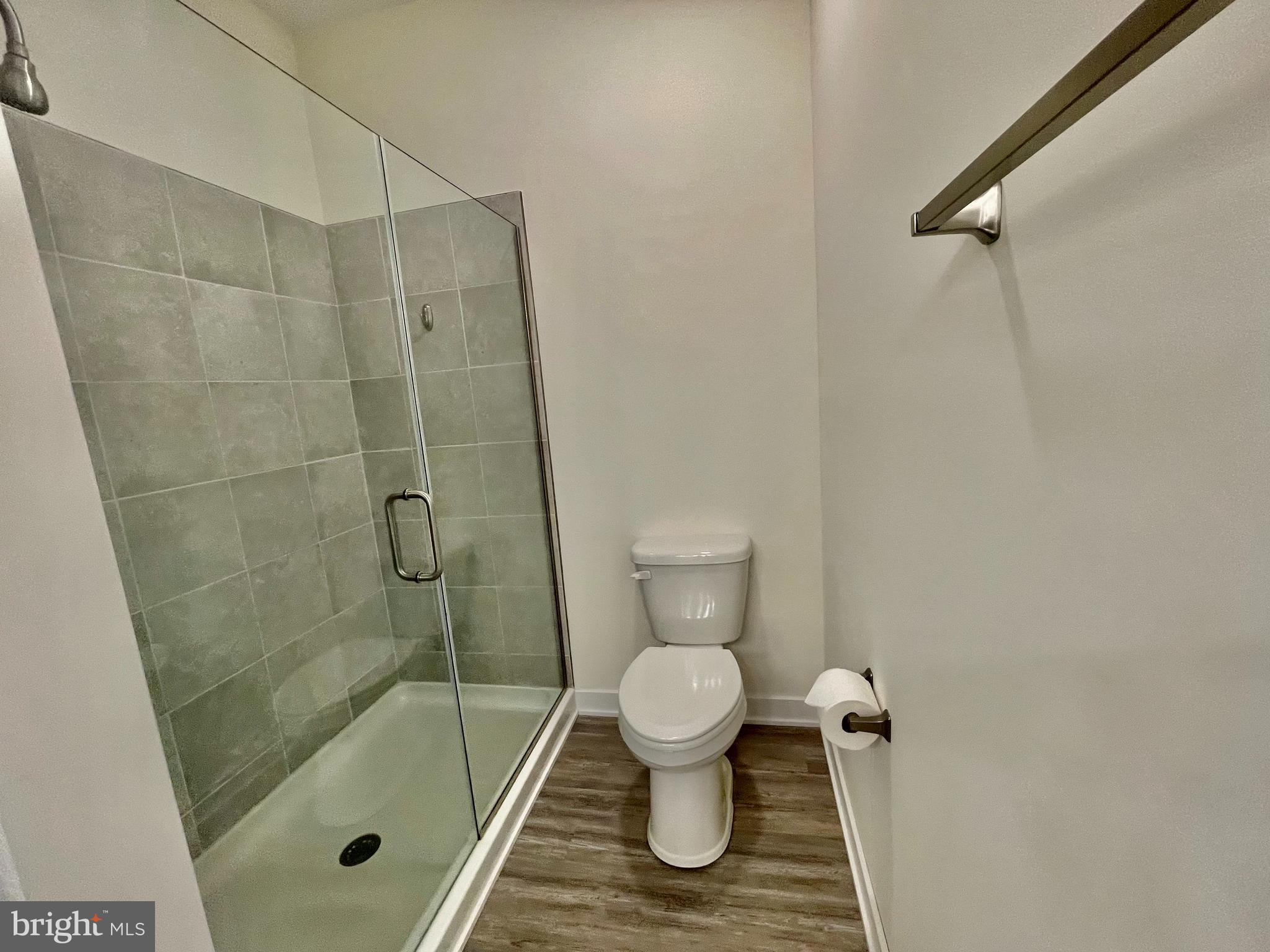 33707 Skiff Alley, Unit 6309 Lewes, DE 19958 - Photo 7 of 11 a bathroom with a granite countertop toilet a sink and shower