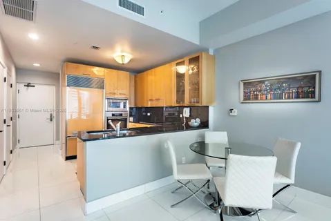 a living room with stainless steel appliances kitchen island granite countertop furniture and a large window