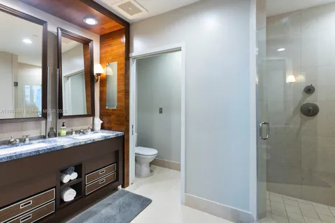 a bathroom with a double vanity sink toilet and shower