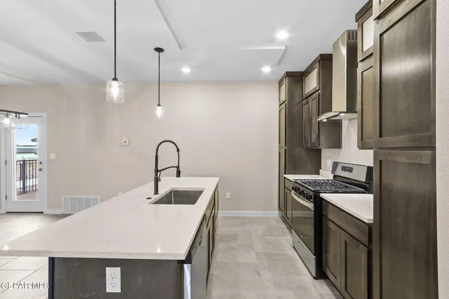 a kitchen that has a sink stainless steel appliances and cabinets