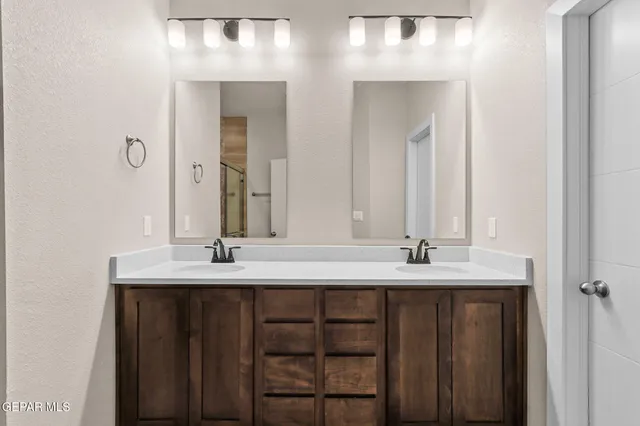 a bathroom with double sink and two mirror
