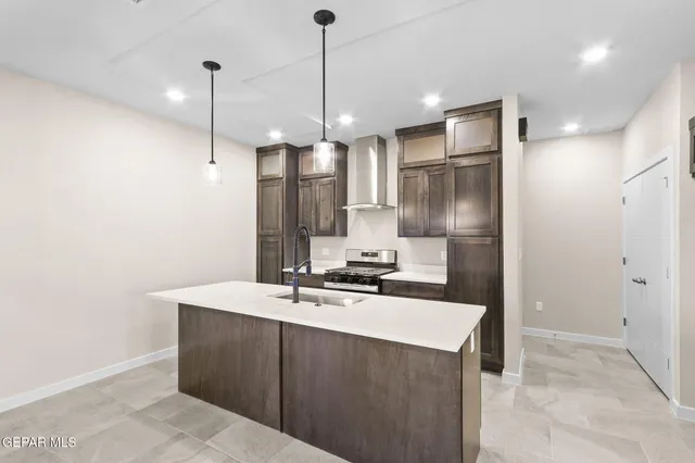 a kitchen with kitchen island a sink stainless steel appliances and a chandelier