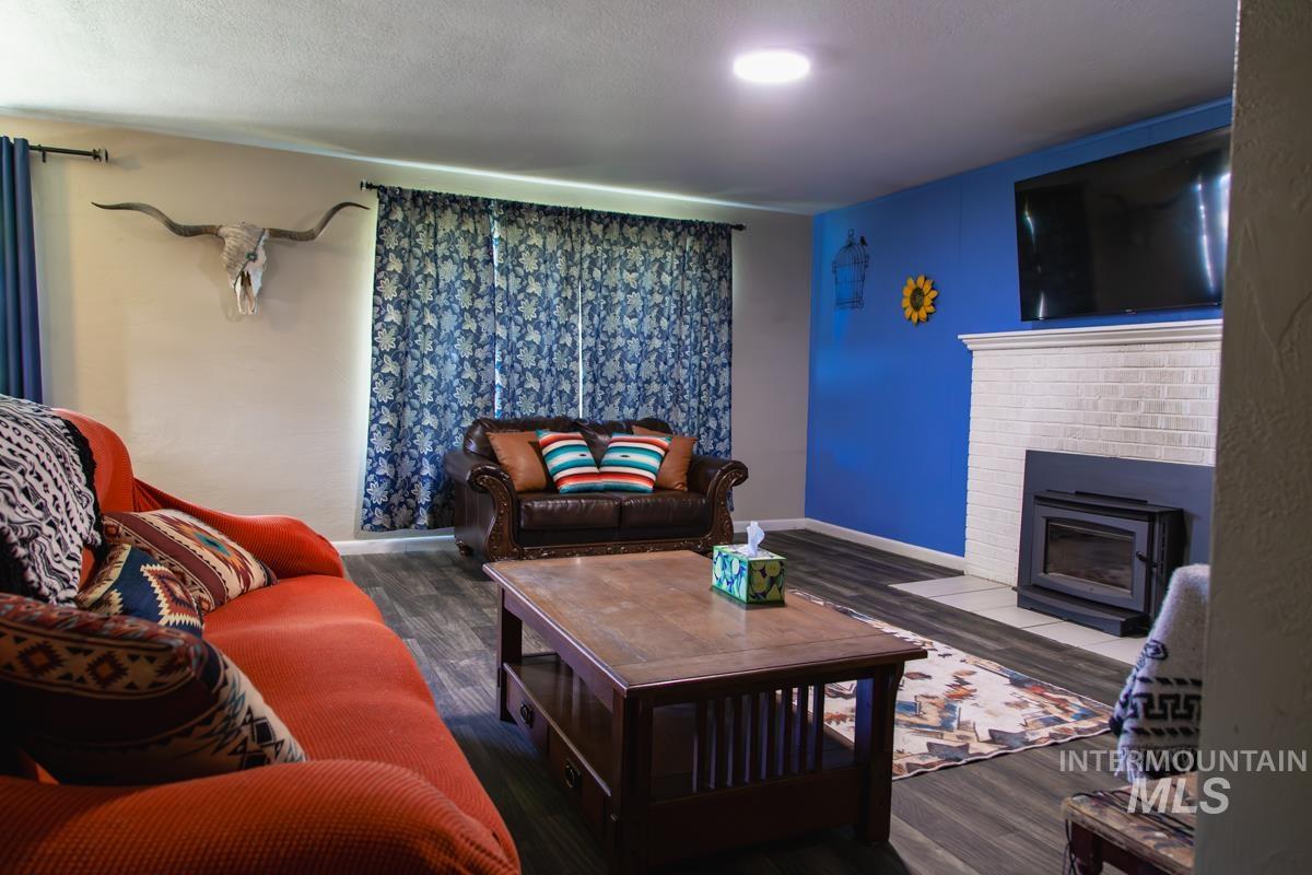 1404 Rochester Street Caldwell, ID 83605 - Photo 9 of 29 Living space featuring wood-finish flooring and a white brick fireplace with an insert
