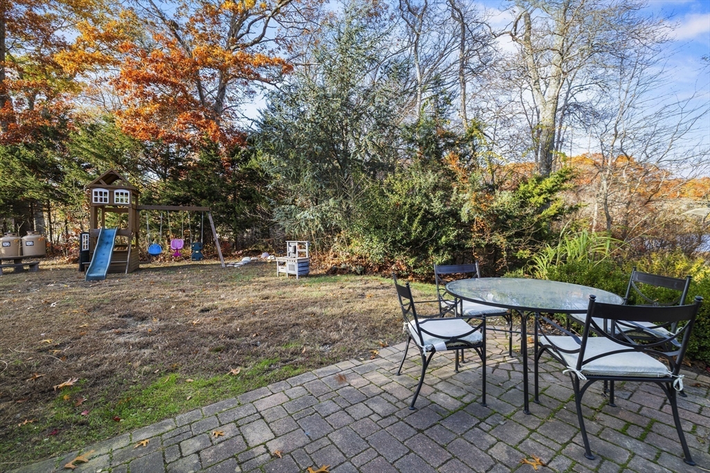 90 R Bartlett Road Plymouth, MA 02360 - Photo 23 of 35 a view of a backyard with table and chairs and a barbeque