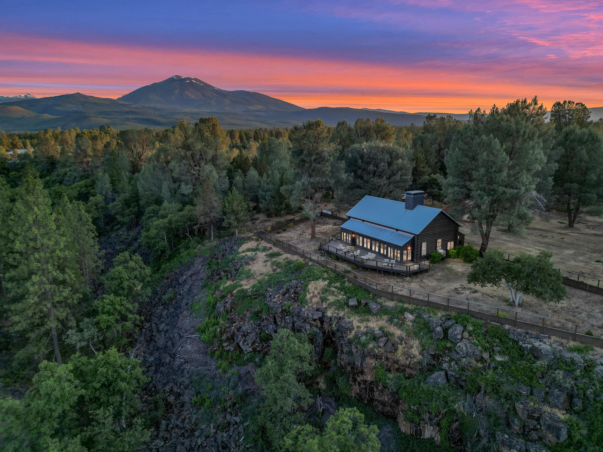 21151 Ridge Road Hat Creek, CA 96040 - Photo 2 of 68 a view of a lush green hillside and a building in the background