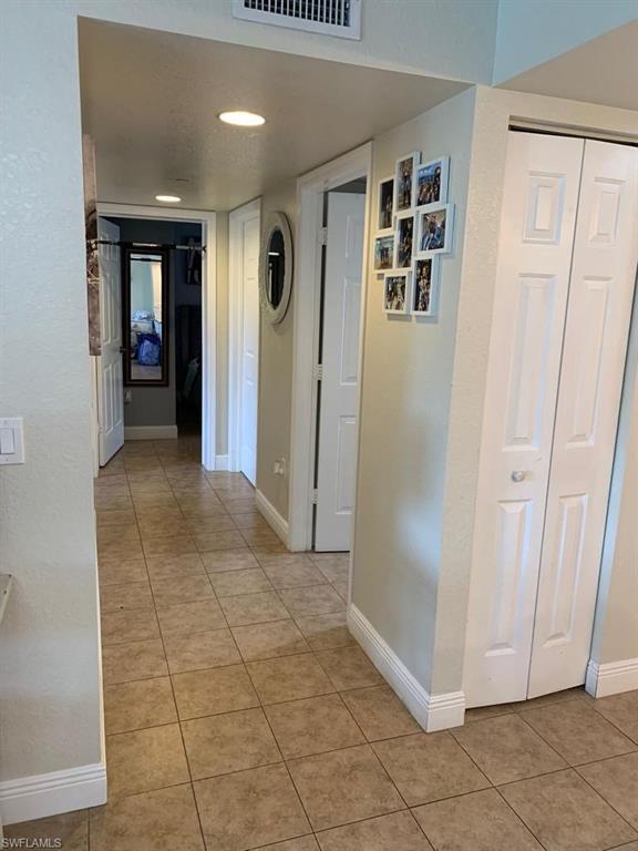 8224 Key Royal Circle, Unit 223 Naples, FL 34119 - Photo 11 of 17 a view of a hallway with wooden floor and closet