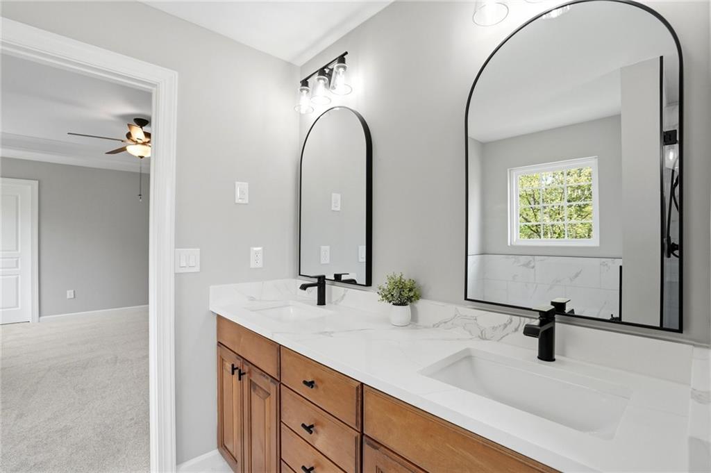 7812 Keepsake Lane Flowery Branch, GA 30542 - Photo 17 of 78 a bathroom with a double vanity sink and a mirror