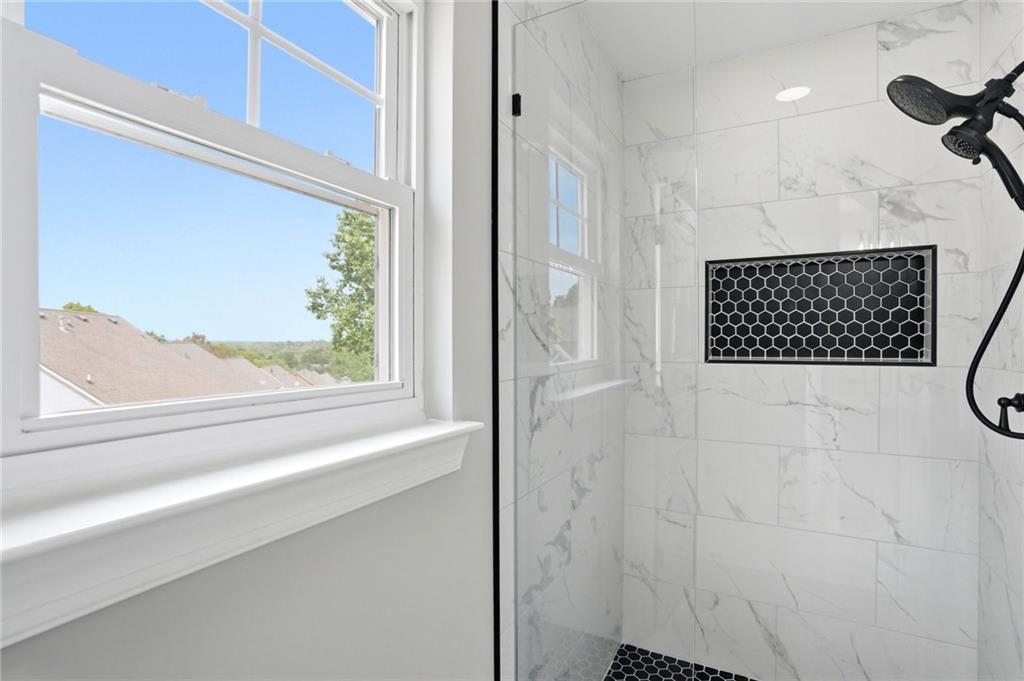 7812 Keepsake Lane Flowery Branch, GA 30542 - Photo 19 of 78 a bathroom with a shower and a window