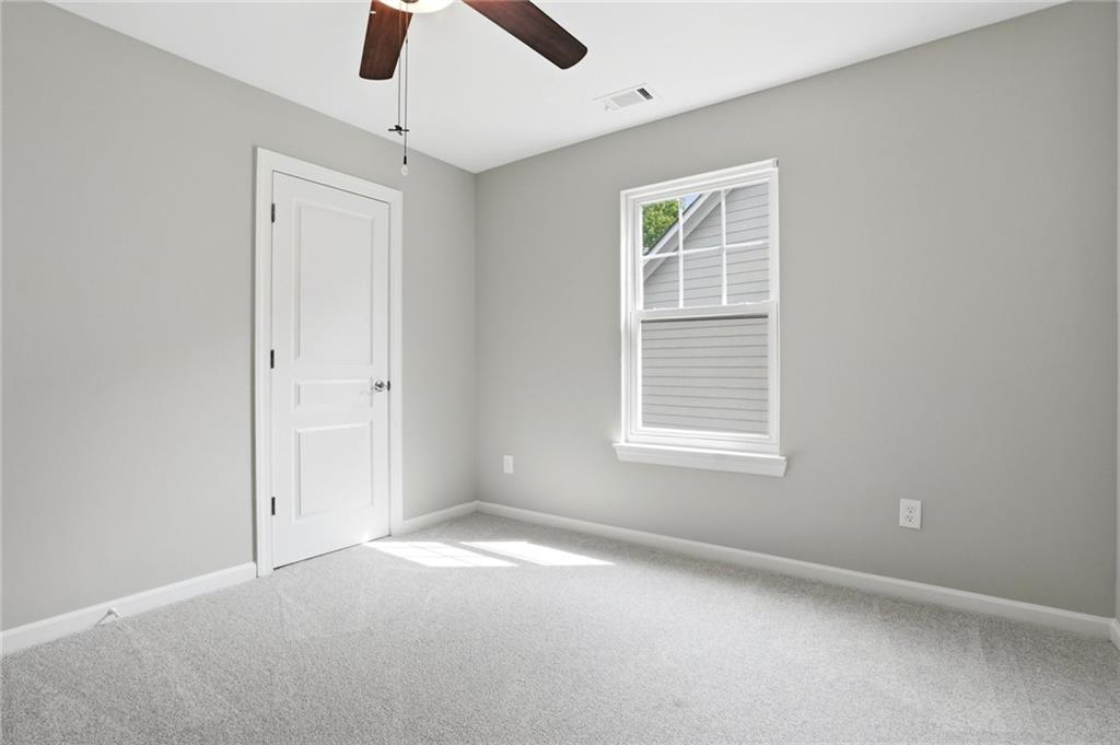 7812 Keepsake Lane Flowery Branch, GA 30542 - Photo 20 of 78 an empty room with chandelier fan and windows