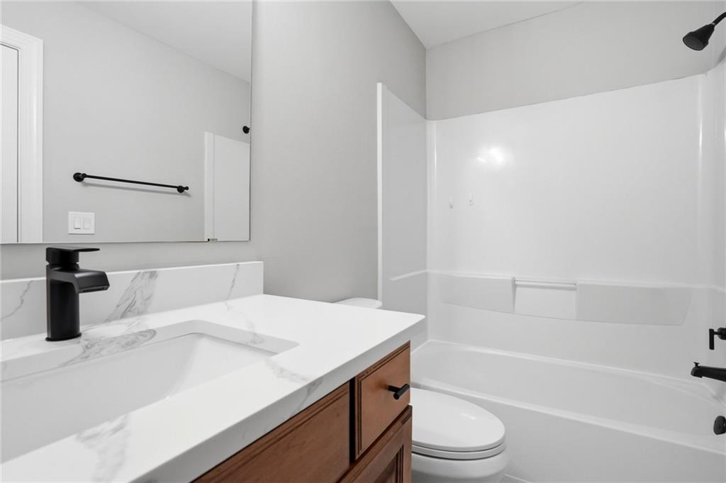 7812 Keepsake Lane Flowery Branch, GA 30542 - Photo 22 of 78 a bathroom with a sink a toilet and a bathtub